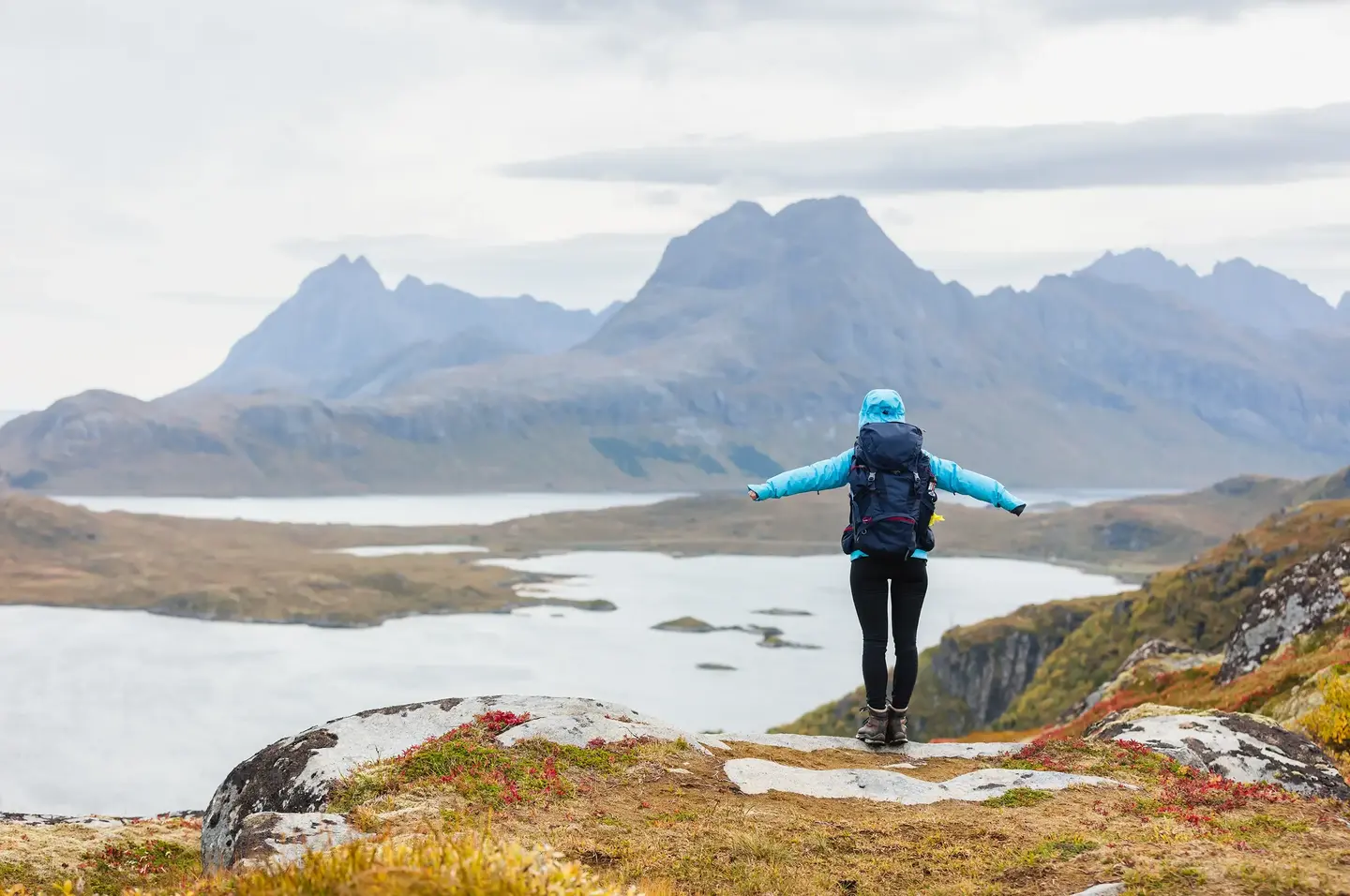Turgåer med ryggsekk nyter utsikten fra toppen av en fjelltopp.